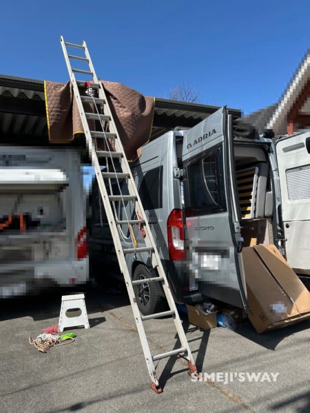 Lift the roof air conditioner onto the roof using a stepladder and arm strength.